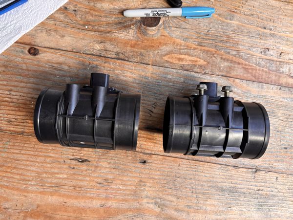 End-on view through the bore of OEM and aftermarket MAF sensors, showing the internal vanes